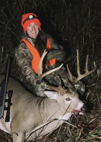 Allyssa Brown with harvested buck in field.