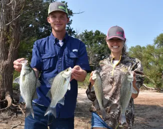 Boy and girl show the white bass caught at Kaw Lake.  Photo by Wade Free
