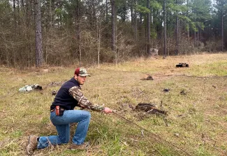 A researcher prepares to extract wild turkeys from beneath a rocket-propelled capture net after a successful launch in southeastern Oklahoma. (OCFWRU)