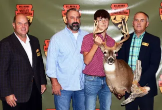 Recognizing the winner of the 2021 Outdoor Oklahoma Adventures raffle youth deer hunt are, from left, Wildlife Commissioner Chad Dillingham, father Todd Yates, winner Eli Yates, and ODWC Assistant Director Wade Free.