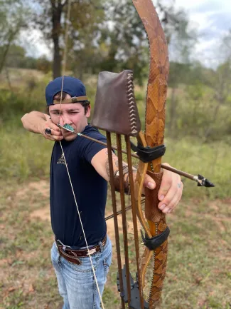 A man draws a bow with an arrow