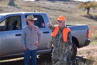 A biologist and a hunter have a conversation in the field. 