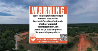 A sign reads "WARNING. Use of range is prohibited during all phases of construction. For more information about public shooting ranges visit wildlifedepartment.com or scan the qr code for updates. We appreciate your patience.