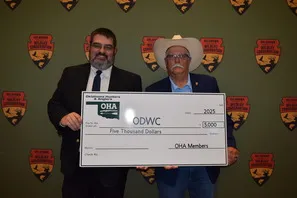 Damon Springer and Oklahoma Hunters and Anglers President Rick Nolan stand behind a large check for $5,000 that was donated to the Oklahoma Department of Wildlife Conservation new archery range at the Arcadia Conservation Education Area.