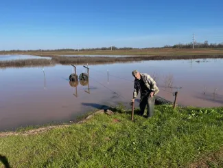 John Sanders works with some of the water control structures that he designed and built for his property. 