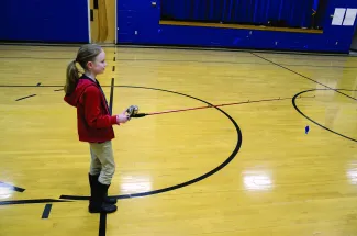 A girl holding a spincast rod/reel. 