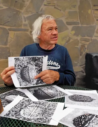 A man holds a black and white photo of a box turtle