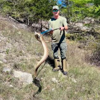 Investigator Austin Jackson handles a rattlesnake while in training on how to handle venomous reptiles.