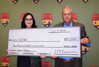 woman and man holding large check